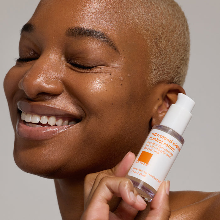 Woman hold white product by the side of her cheek.