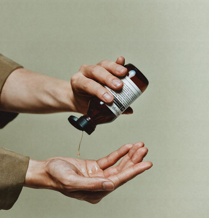 A pair of hands using the Aesop Immaculate facial tonic