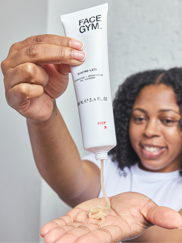 a woman holding a tube of cream