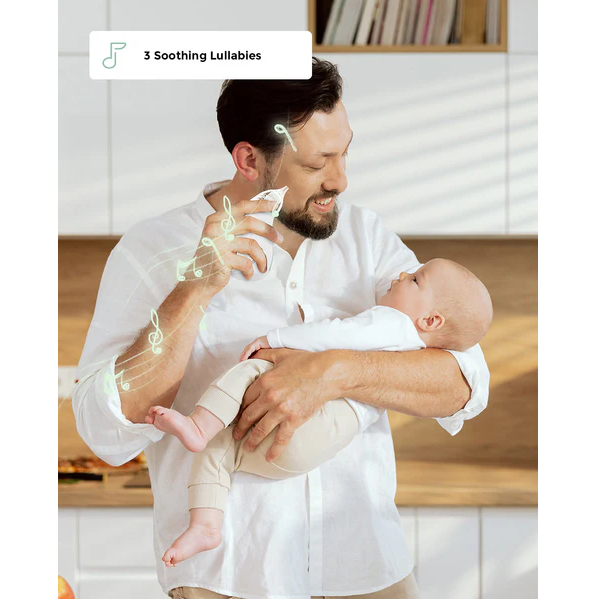 Momcozy Nasal Aspirator used by smiling man holding baby in white kitchen, text reads "3 Soothing Lullabies" with musical notes graphic