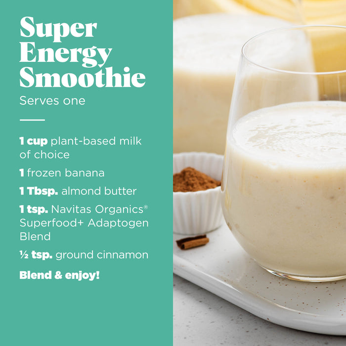 A glass of creamy smoothie on a plate with a spoonful of powder placed next to it. Text on the image lists ingredients for a Super Energy Smoothie, including plant-based milk, banana, almond butter, Navitas Organics blend, and ground cinnamon.