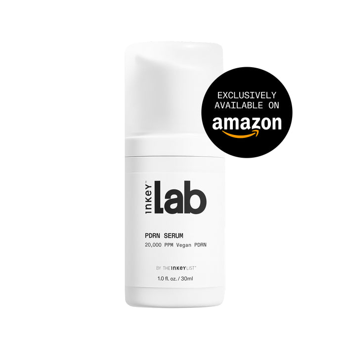 A white cylindrical bottle of Inkey Lab Porn Serum with a black and white label, featuring a black circular badge on the right that reads 'EXCLUSIVELY AVAILABLE ON amazon'.