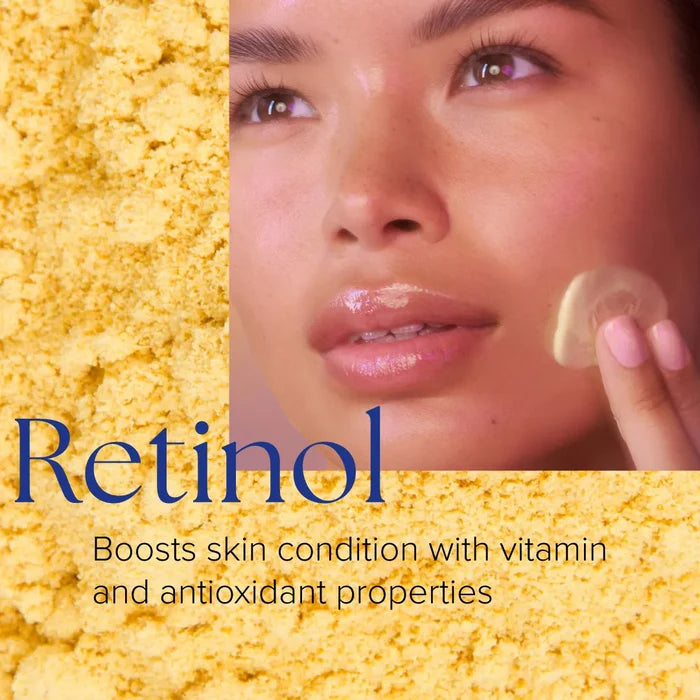 Close-up of woman applying creamy beige Retinol+ Emulsion 0.3 to cheek, yellow powder background