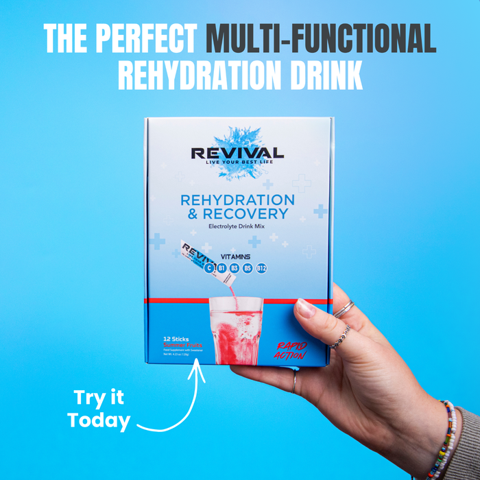 Revival Rehydration & Recovery Electrolyte Drink Mix box held by hand on blue background, showing vitamins C B1 B3 B5 B12, 12 sticks.