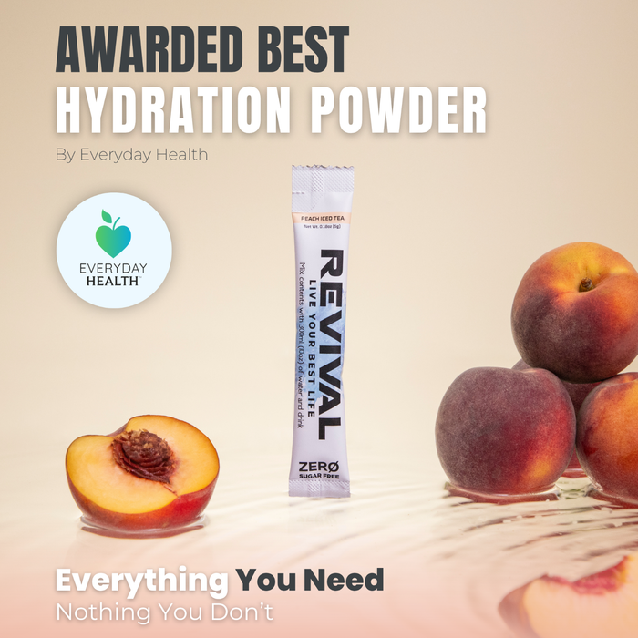 Revival Peach Iced Tea ZERO electrolyte powder stick packet surrounded by fresh peaches on a beige background, Everyday Health award logo visible.