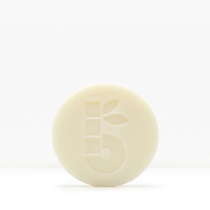 Partial view of a pale shaving bar with decorative geometric cutouts against a white background