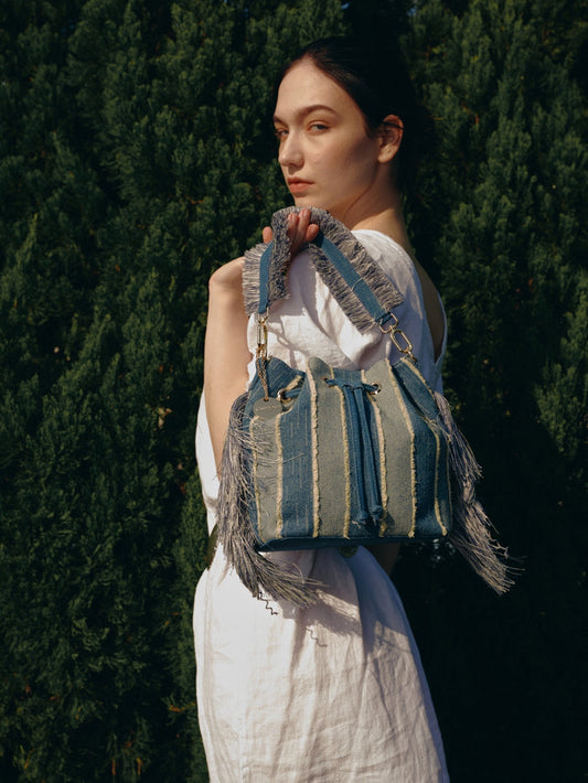 Striped denim patchwork bucket bag with fringe handle and tassel sides wholesale