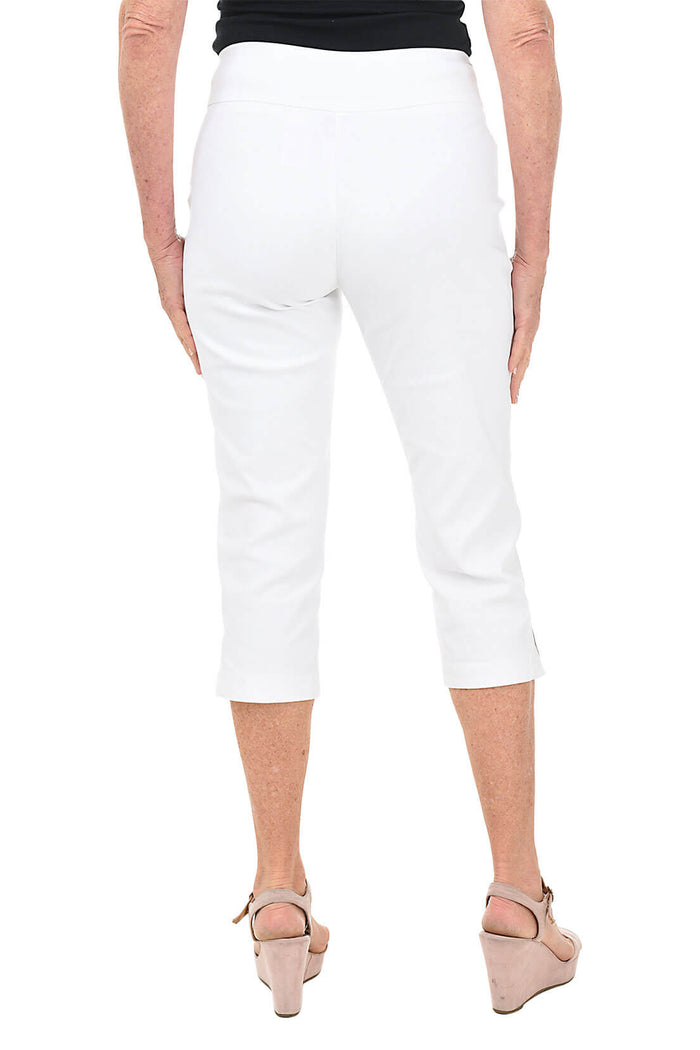 Person wearing white capri pants on a white background. Back shot.