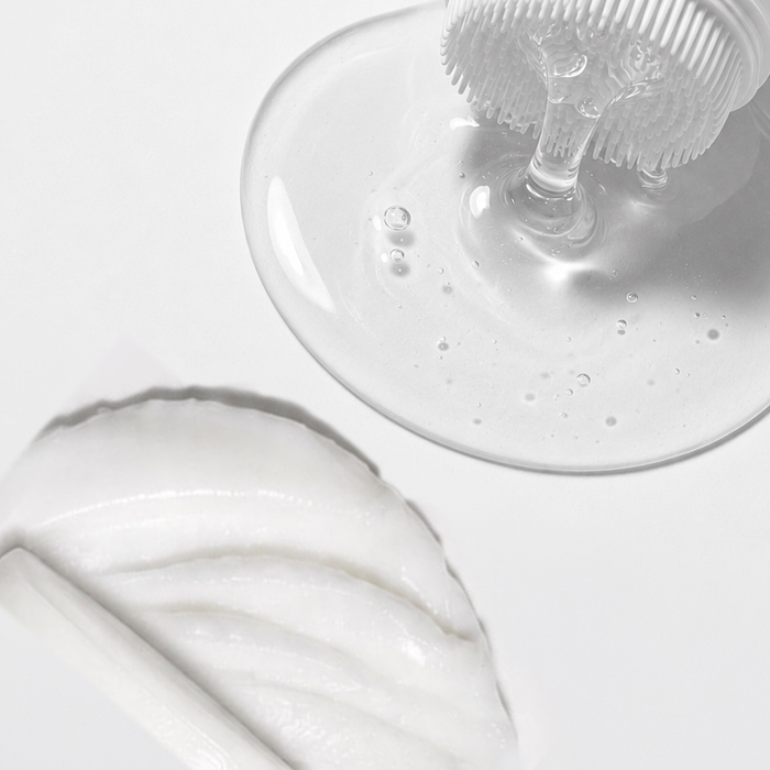 Close-up of clear skincare resting on a white surface.