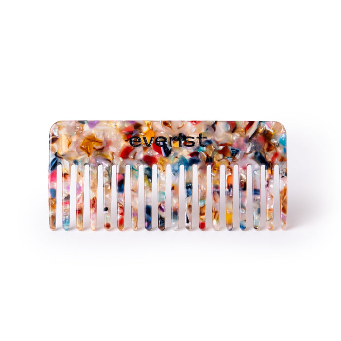 The Confetti Comb by Everist has wide teeth for easy detangling, a vibrant marbled pattern, is made from recycled materials, and features the Everist name. Shown on a clean white background.
